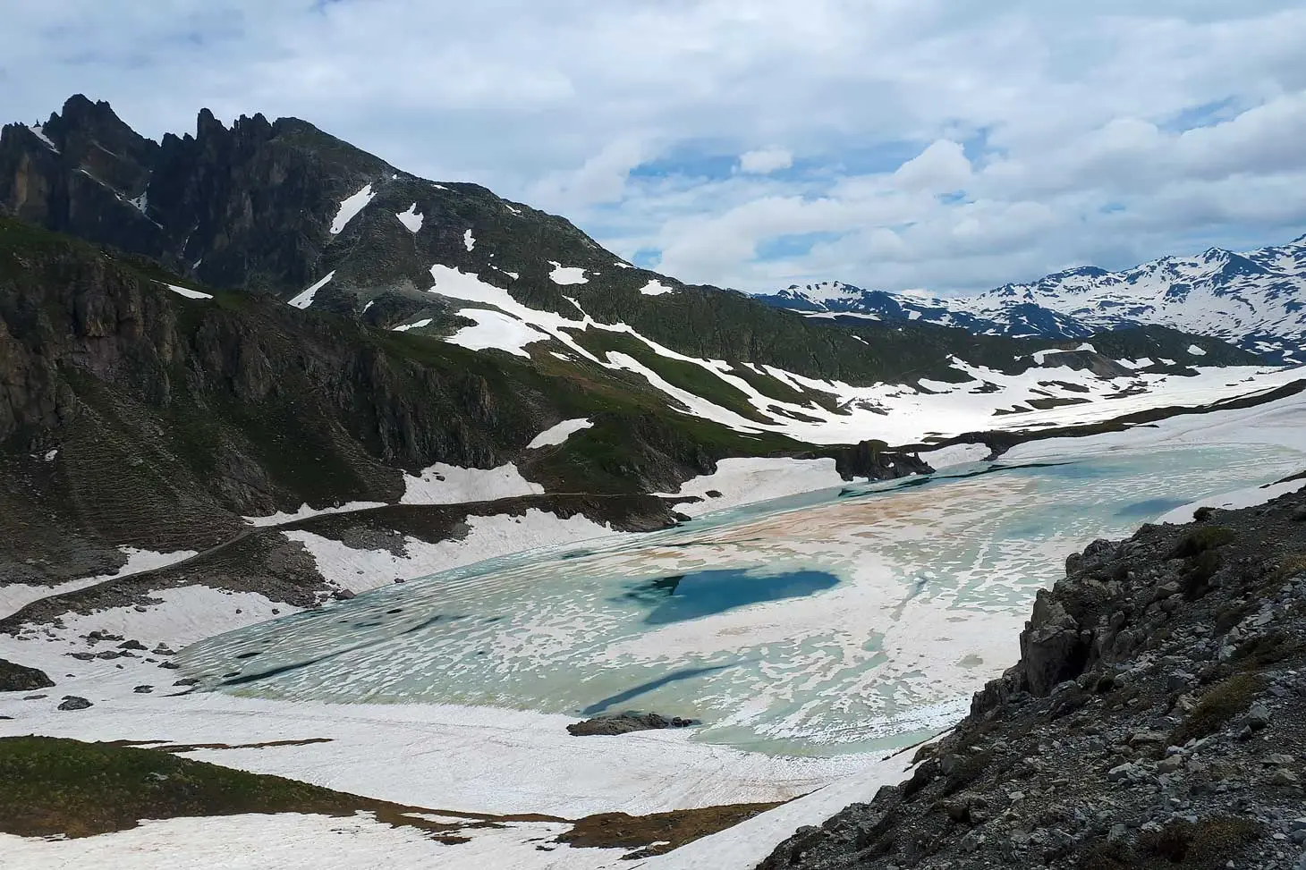 Photographie de lac encore gelé avec présence de micro-algues et micro-organismes visibles en rouge