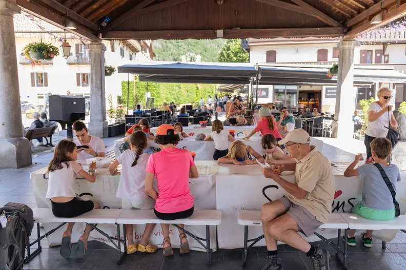 Des enfants autour des tables de l'atelier créatif