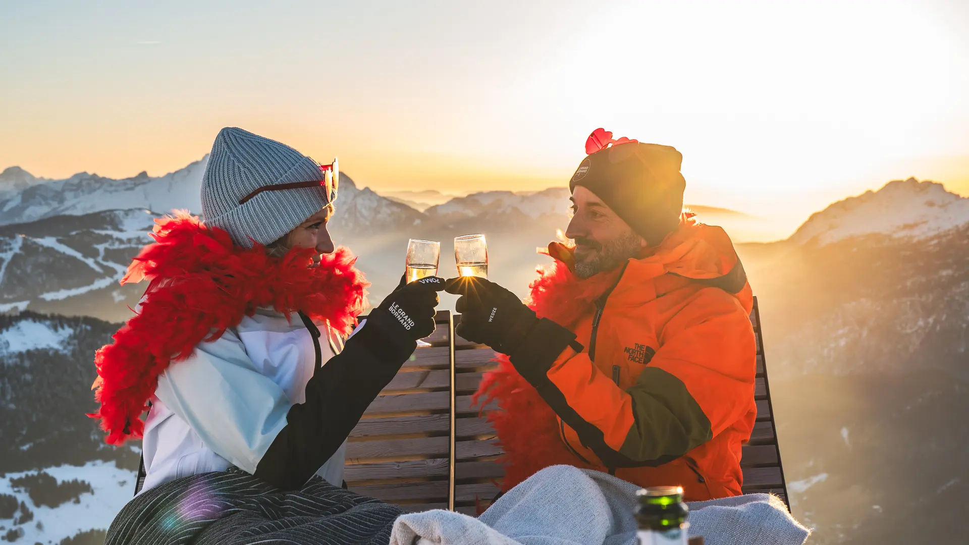 couple sur le domaine skiable qui trinque des flutes à champagne