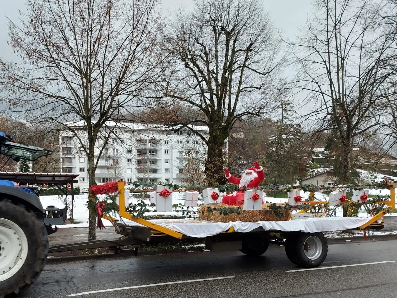 Le Père Noël sur un char trainé par un tracteur.