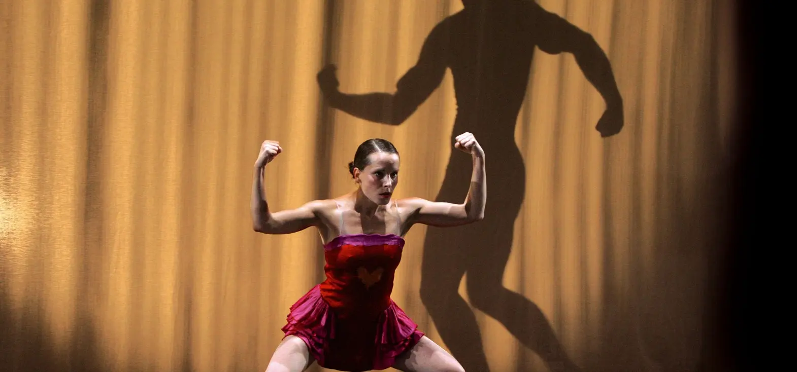 artiste en tutu qui brandit les bras comme musclor