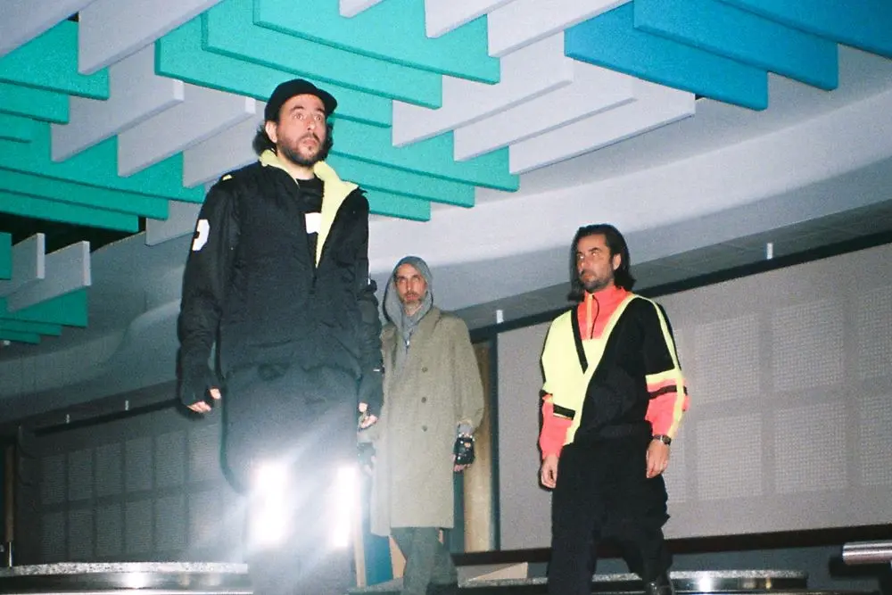 3 personnages comme sur un podium de mode qui défilent