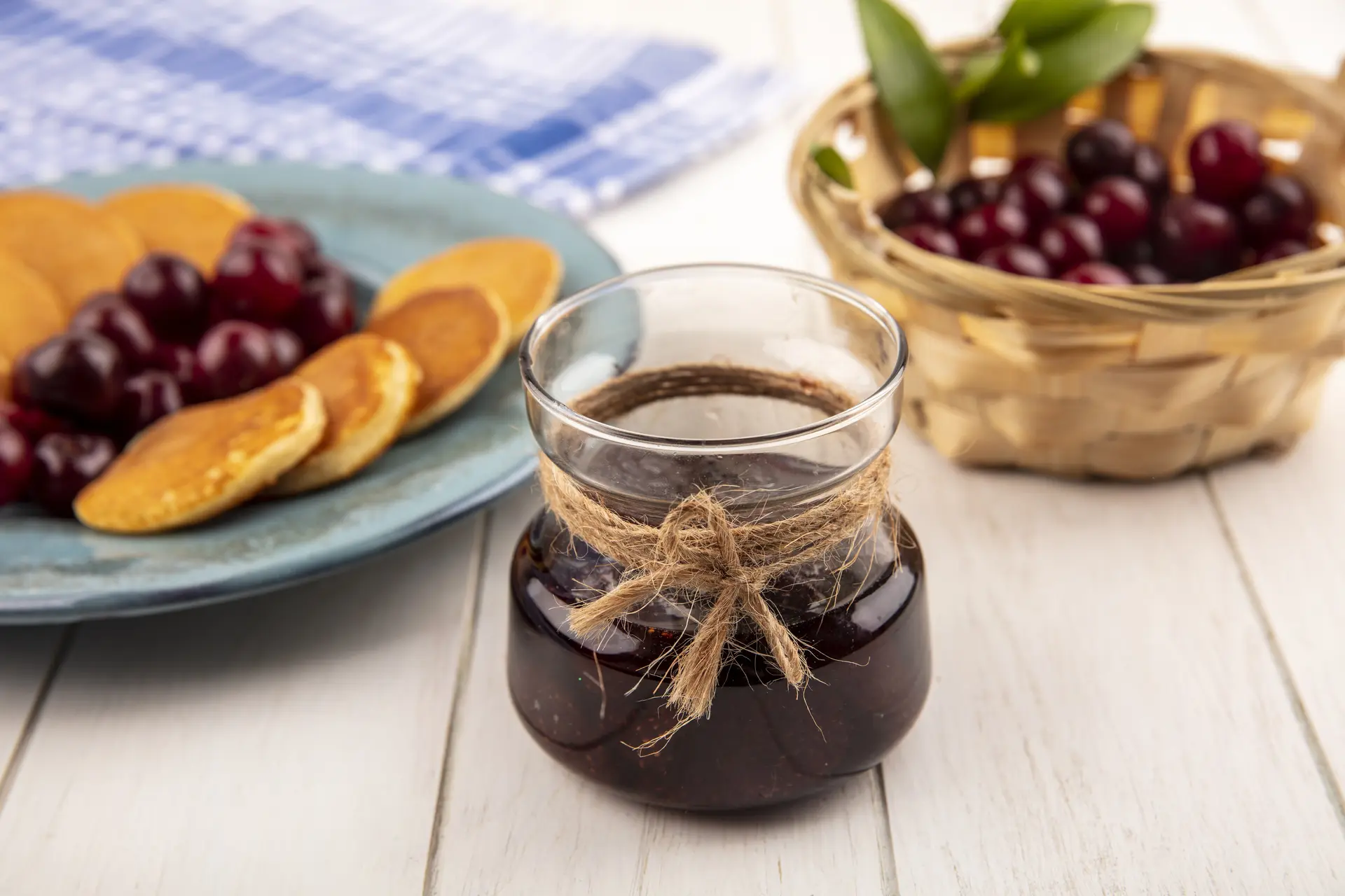 side-view-strawberry-jam-jar-plate-pancakes-cherries-with-basket-cherries-wooden-background