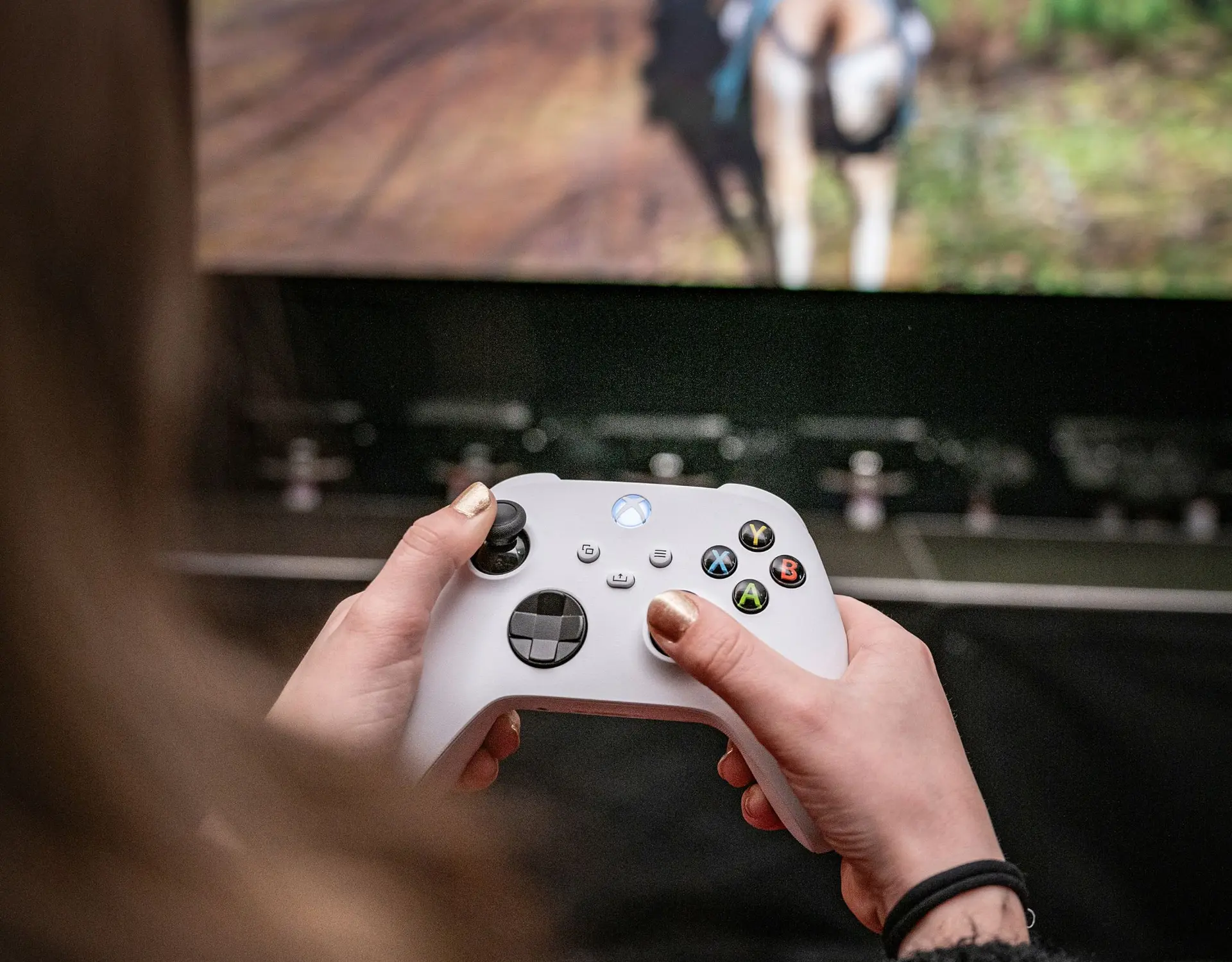 player with a controller in front of a big screen