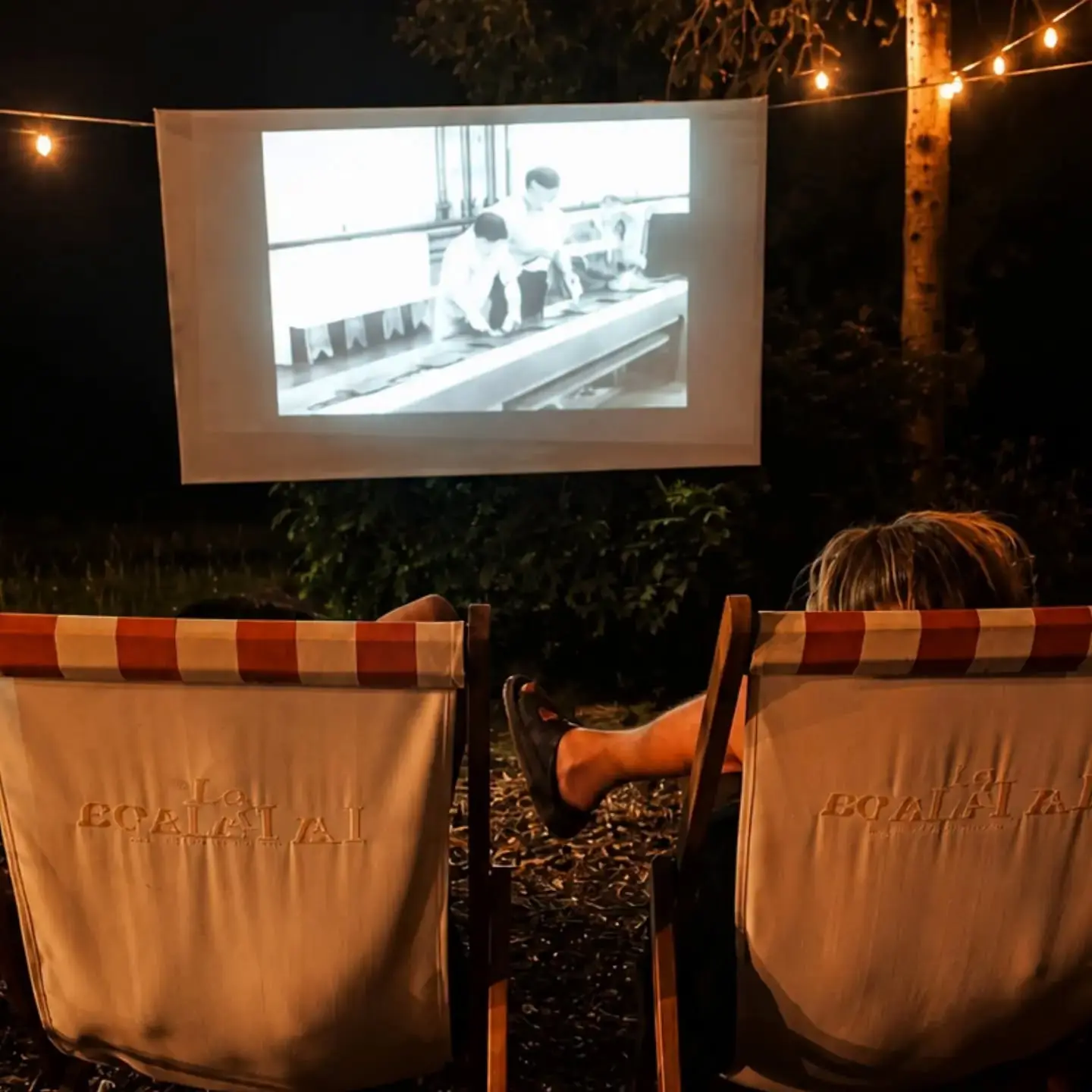 Photo montrant une projection de film avec deux personnes sur leur transat