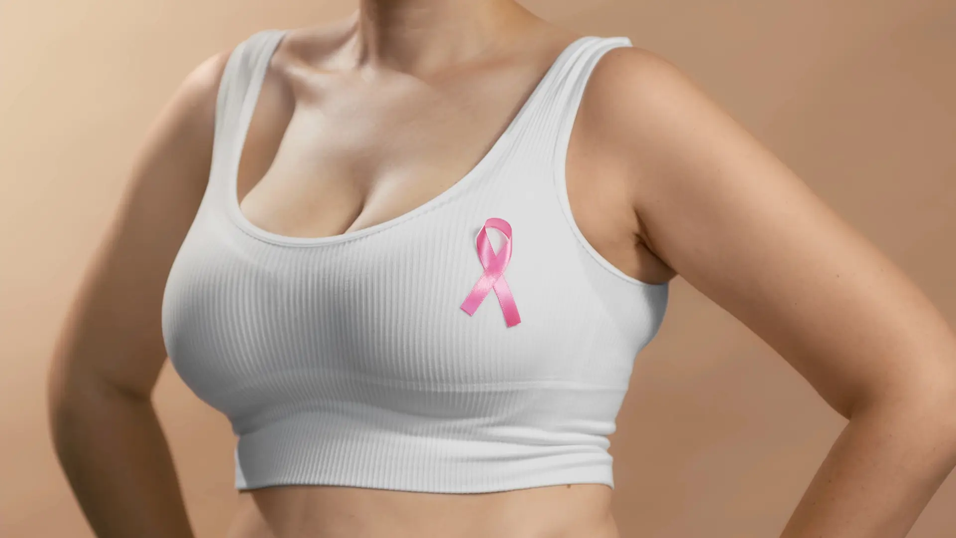 Jeune femme en brassière avec un ruban sur la poitrine pour soutenir octobre Rose