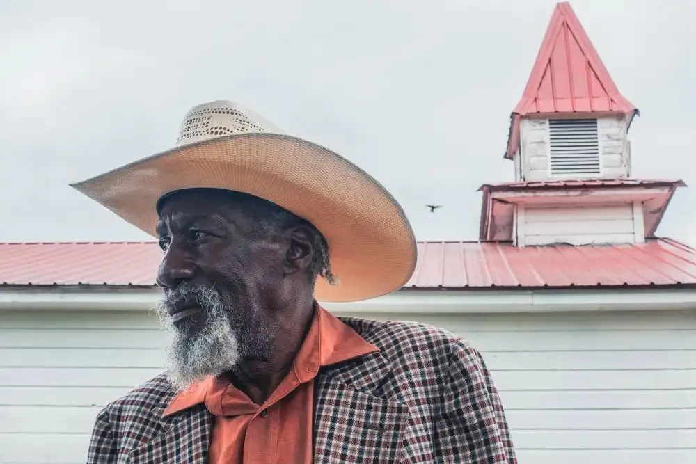 artiste devant une église clocher en bois