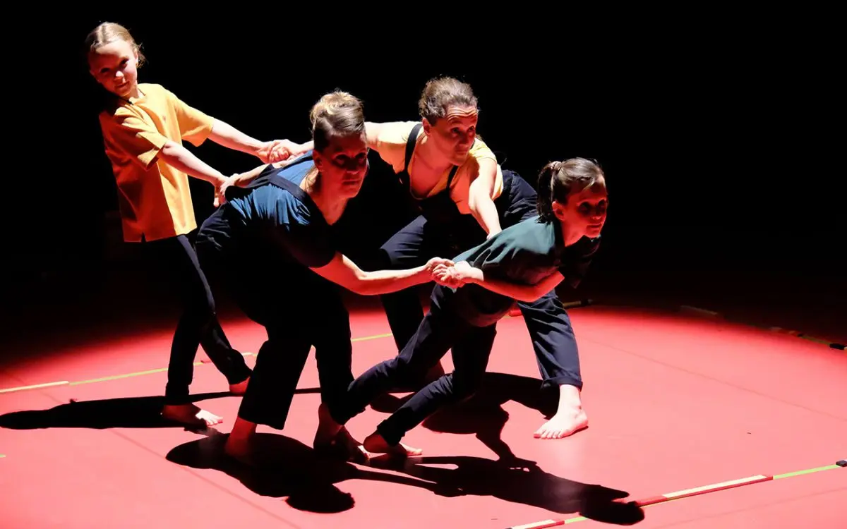 danseurs sur scène qui se tiennent par la main et les bras