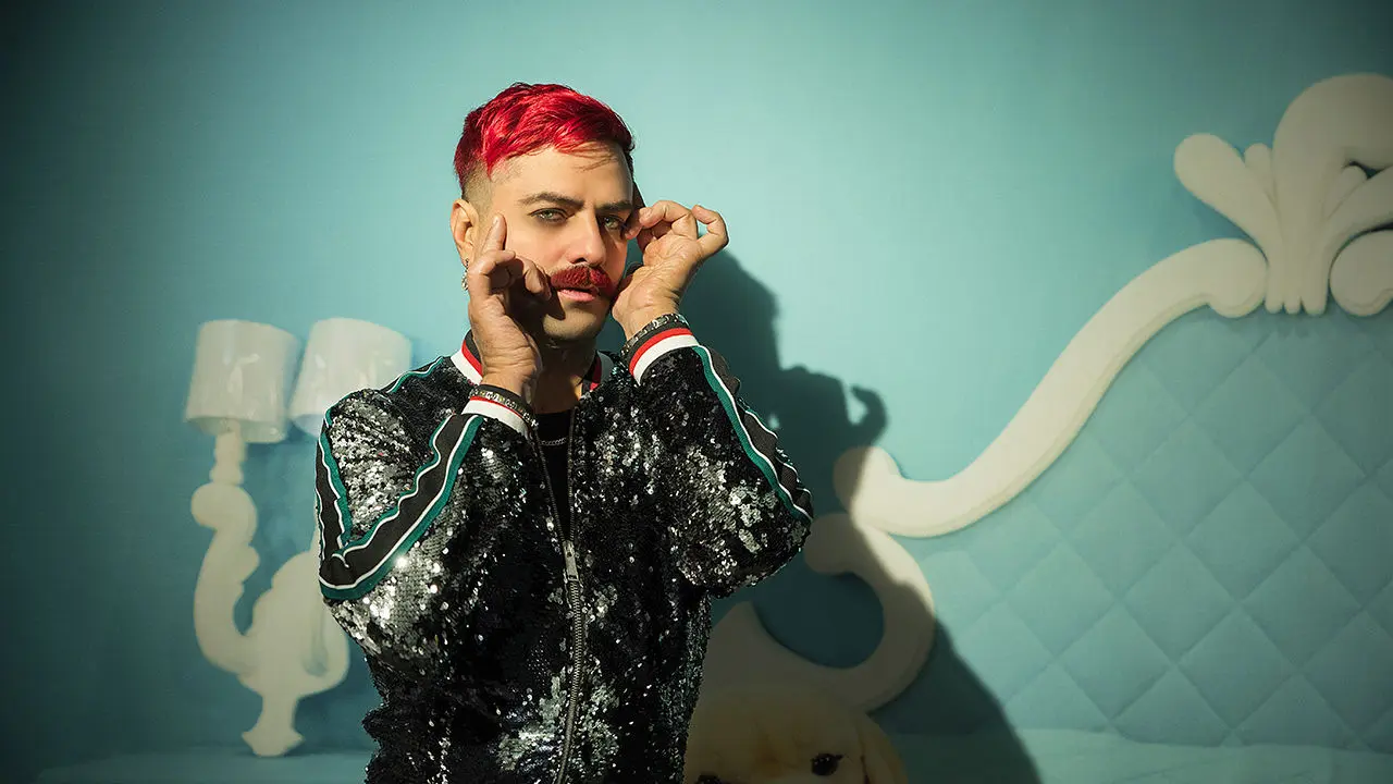 artiste avec un costume pailleté et une moustache et des cheveux rouges