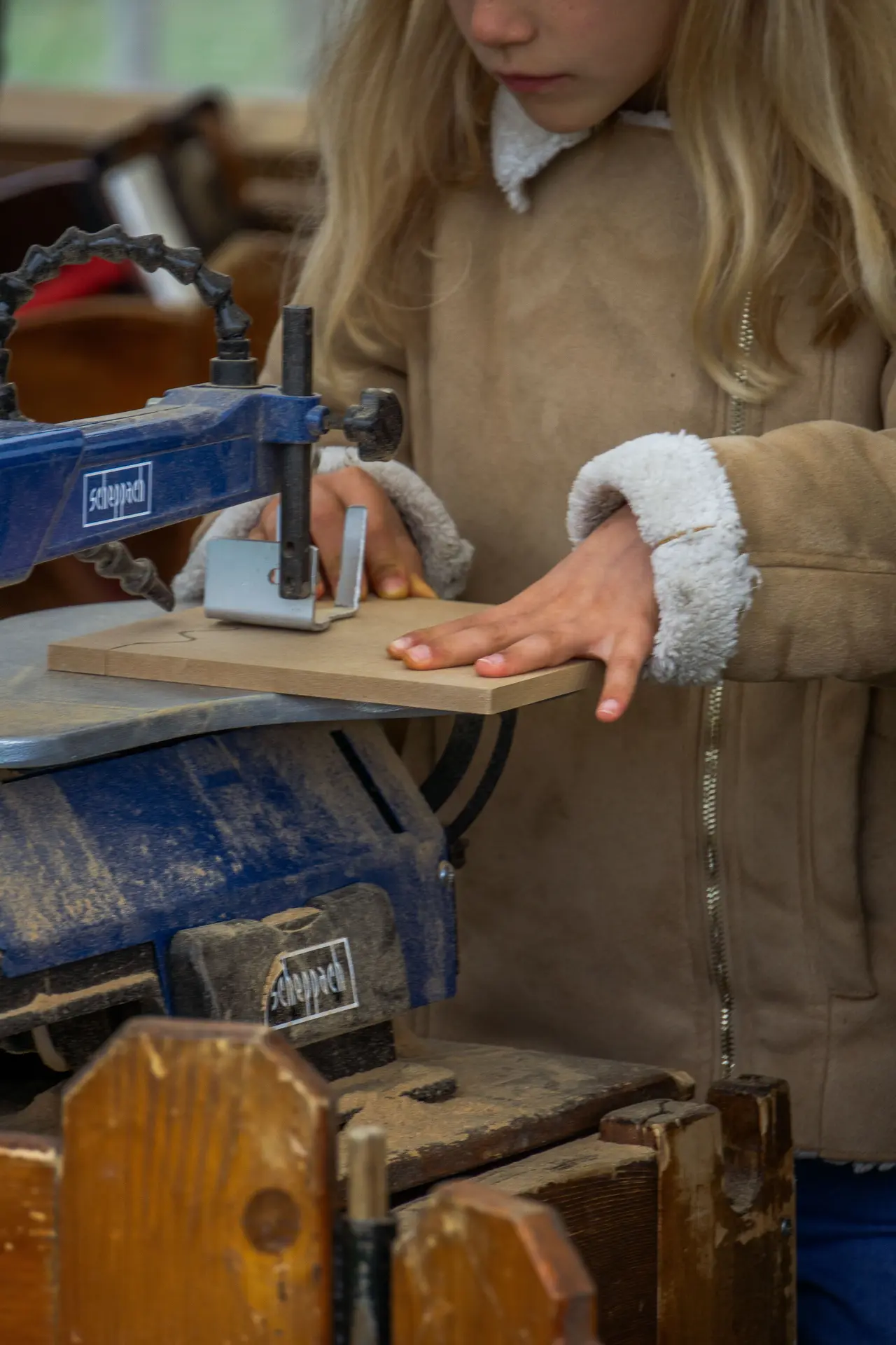 Une petite fille manie une scie sauteuse