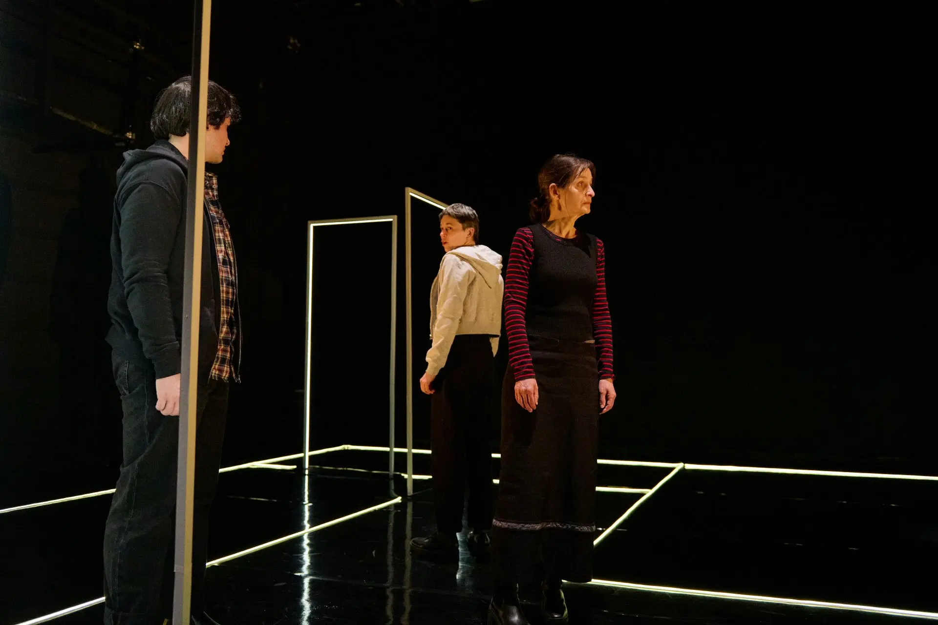 3 artistes sur scène dans le noir