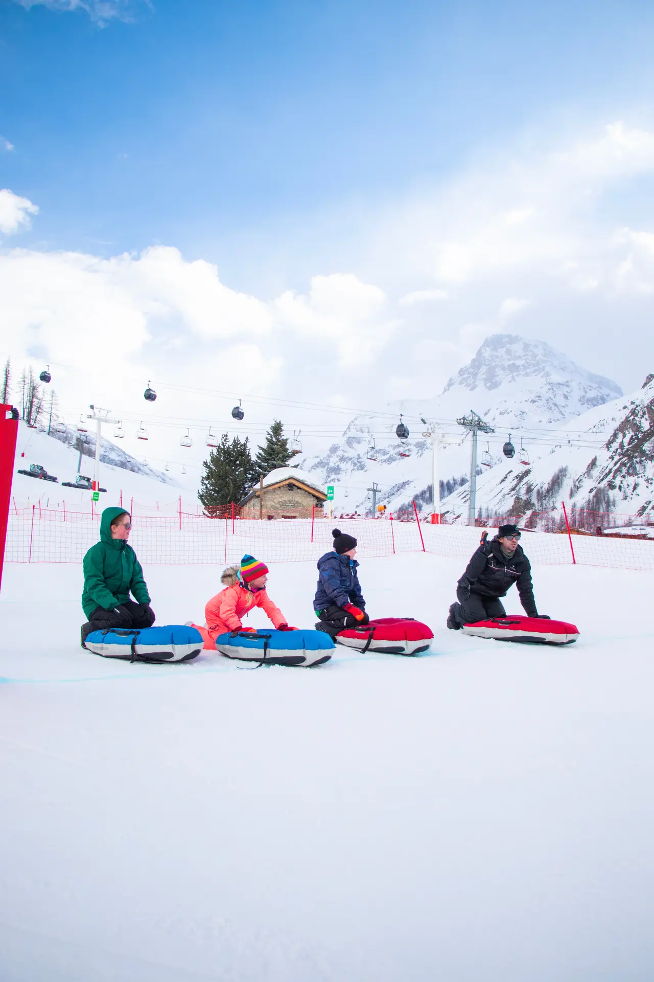 Curling humain en famille à Val d'Isère en hiver sur la piste de la Savonnette