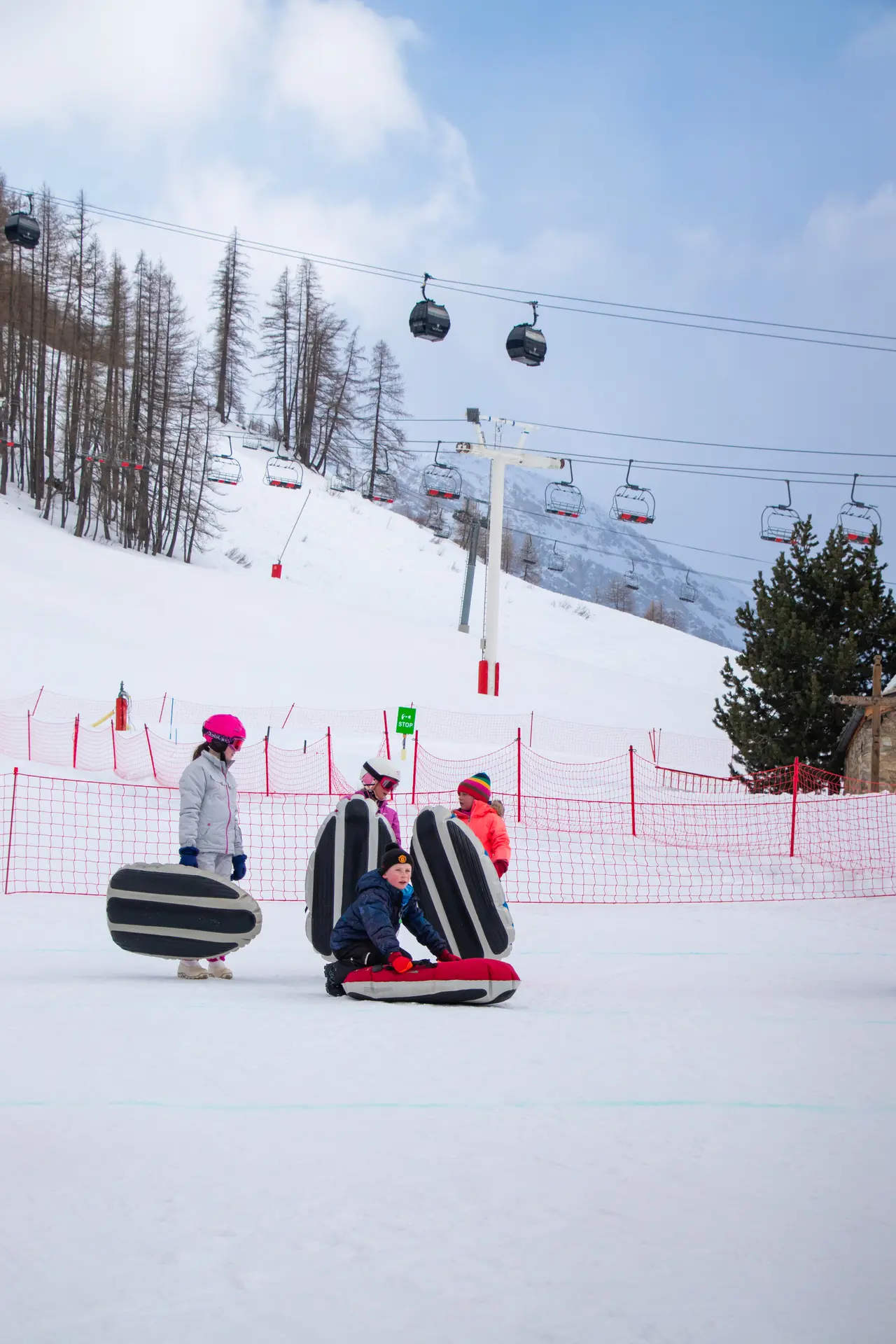 Curling humain en famille à Val d'Isère en hiver sur la piste de la Savonnette