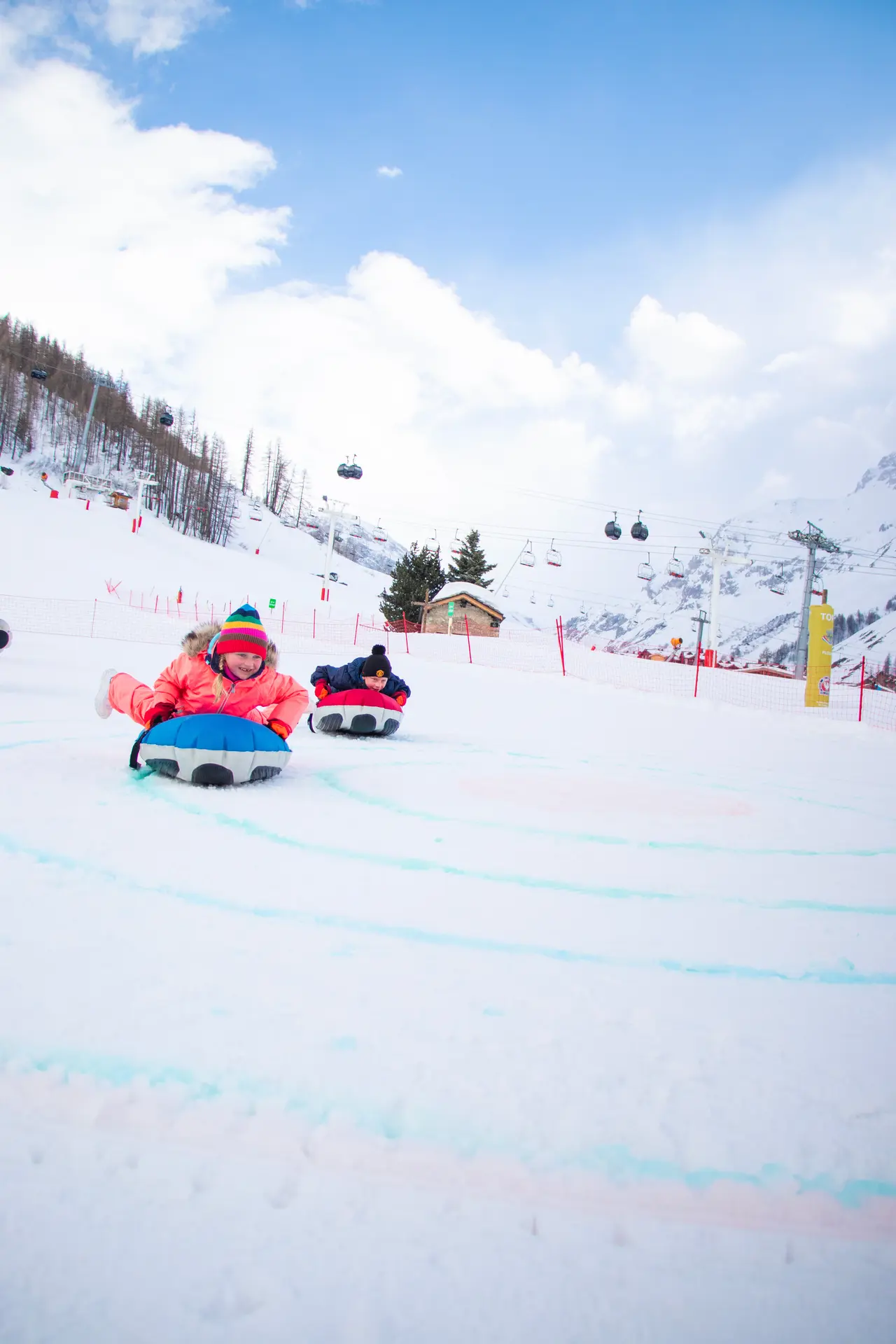 Curling humain en famille à Val d'Isère en hiver sur la piste de la Savonnette