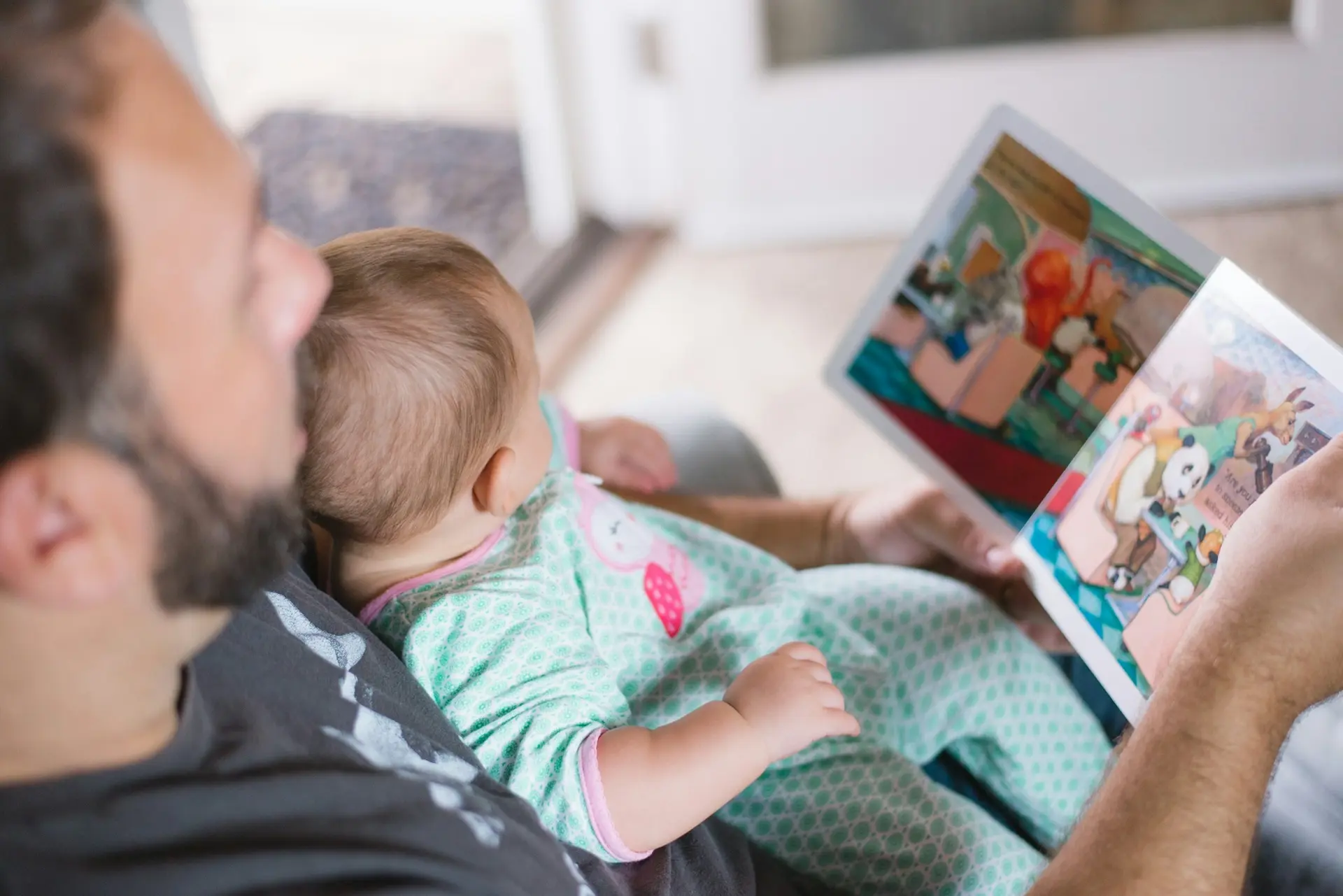Papa lisant avec son bébé sur les genoux