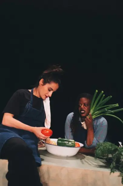 deux femmes sur scène avec des légumes en cuisine