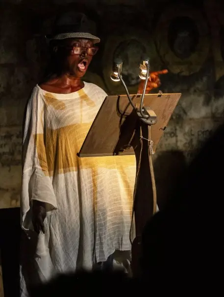 comédienne qui lit un texte sur un pupitre