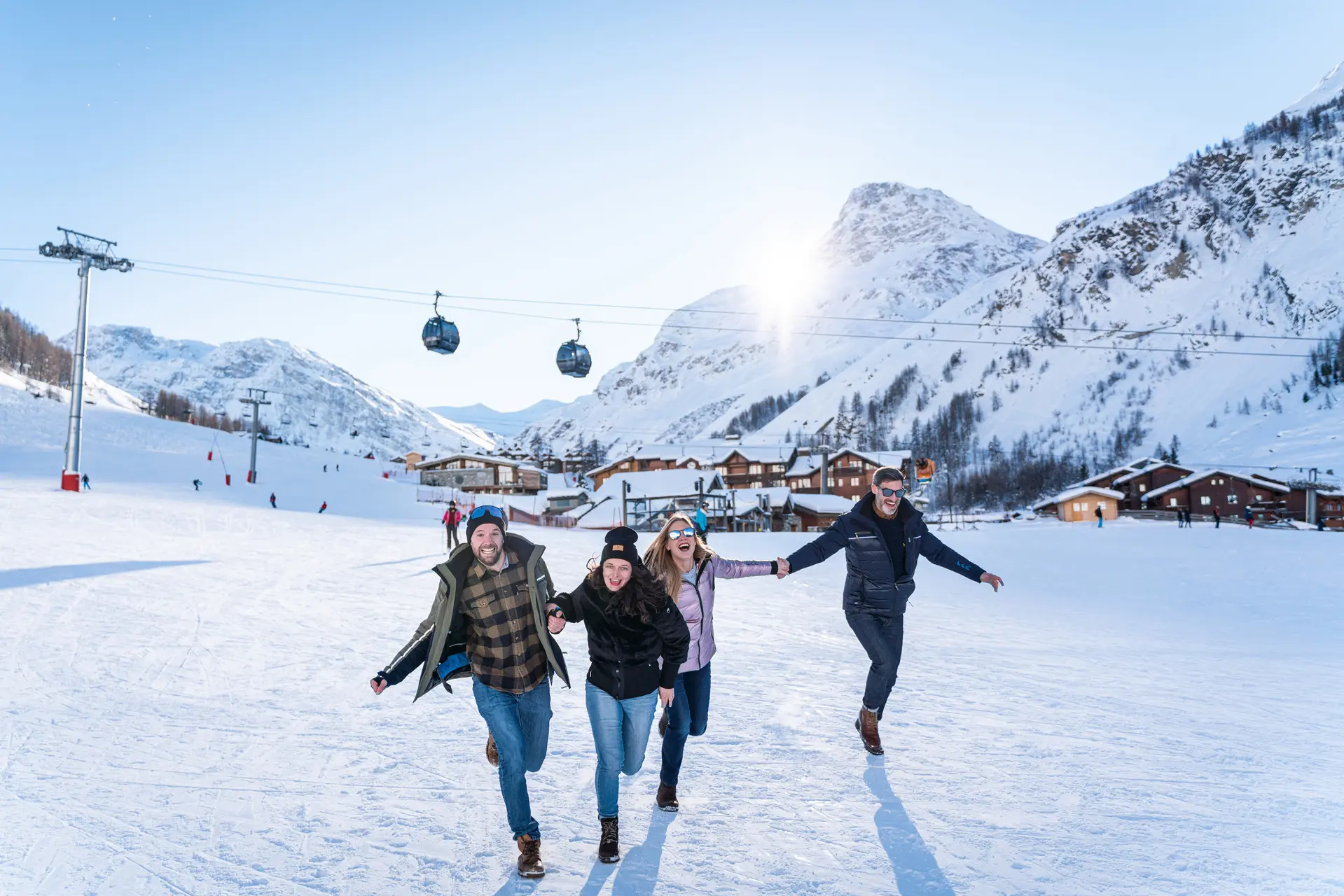 Amis qui courent sur le front de neige de Val d'Isère en hiver