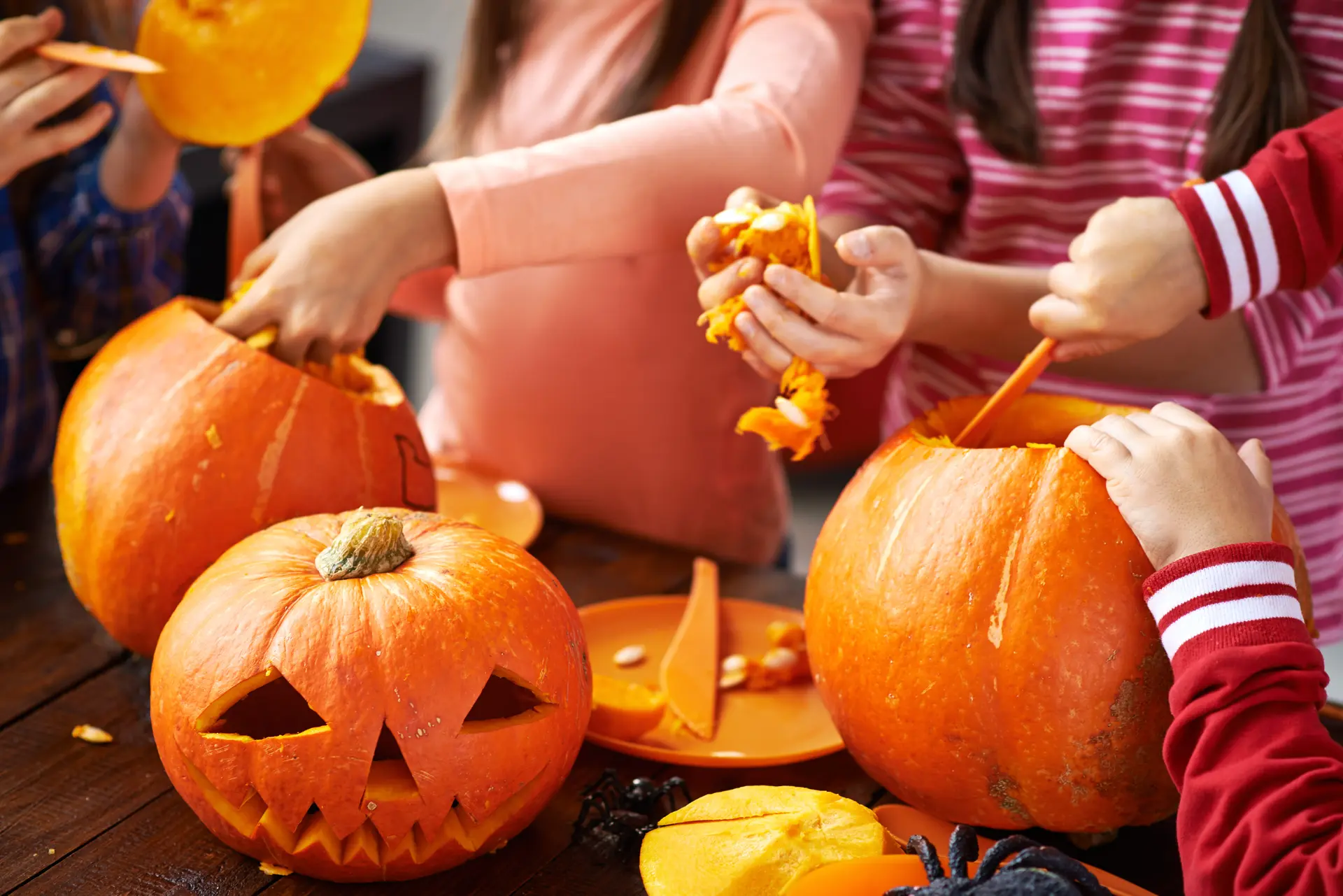 Des enfants creusant des courges pour la déco d'Halloween