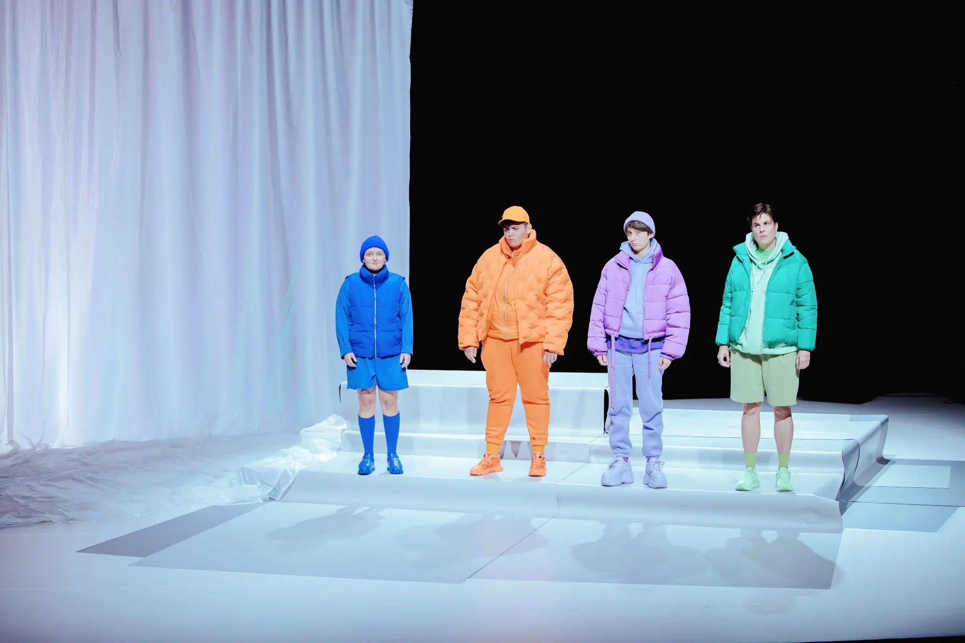 4 personnes en habits de couleur sur scène