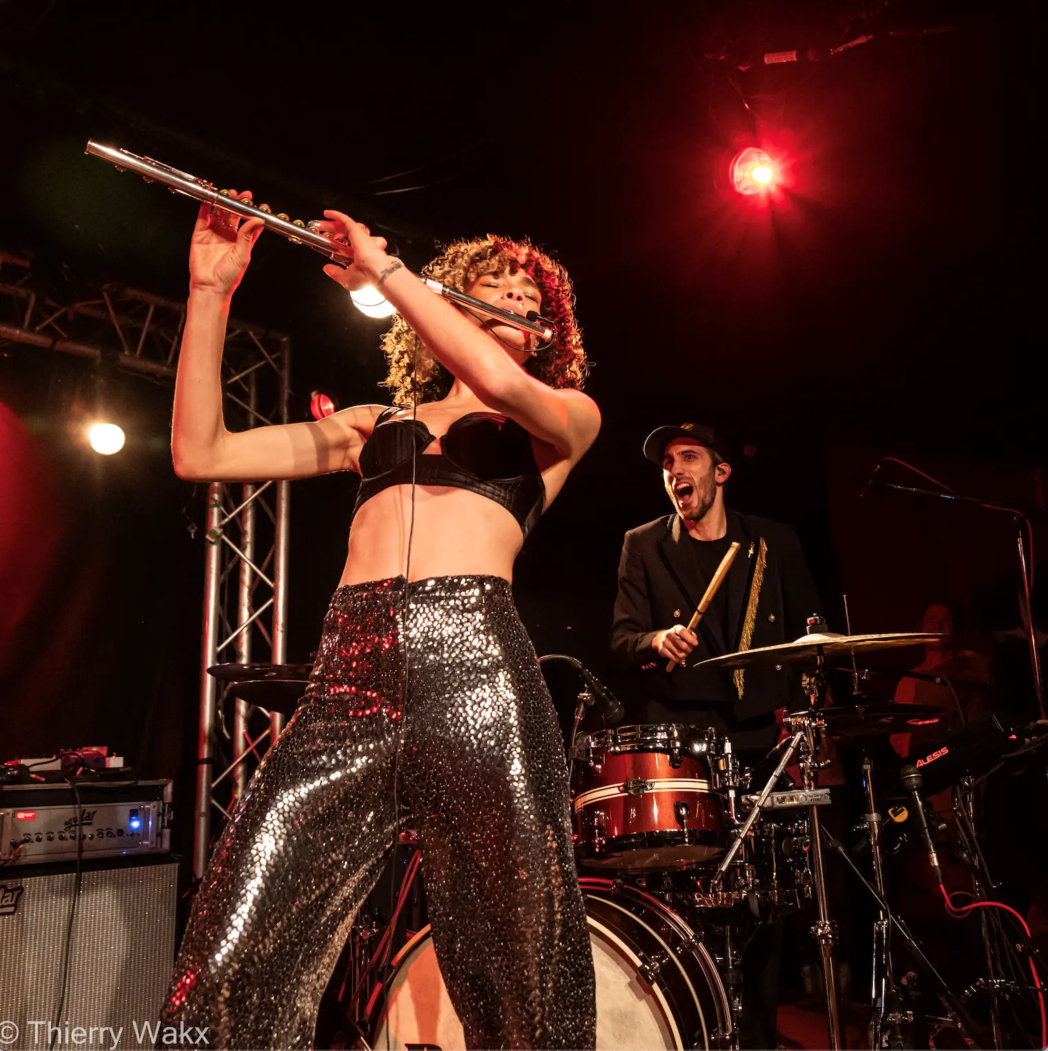 Chanteuse sur scène avec le batteur derrière elle