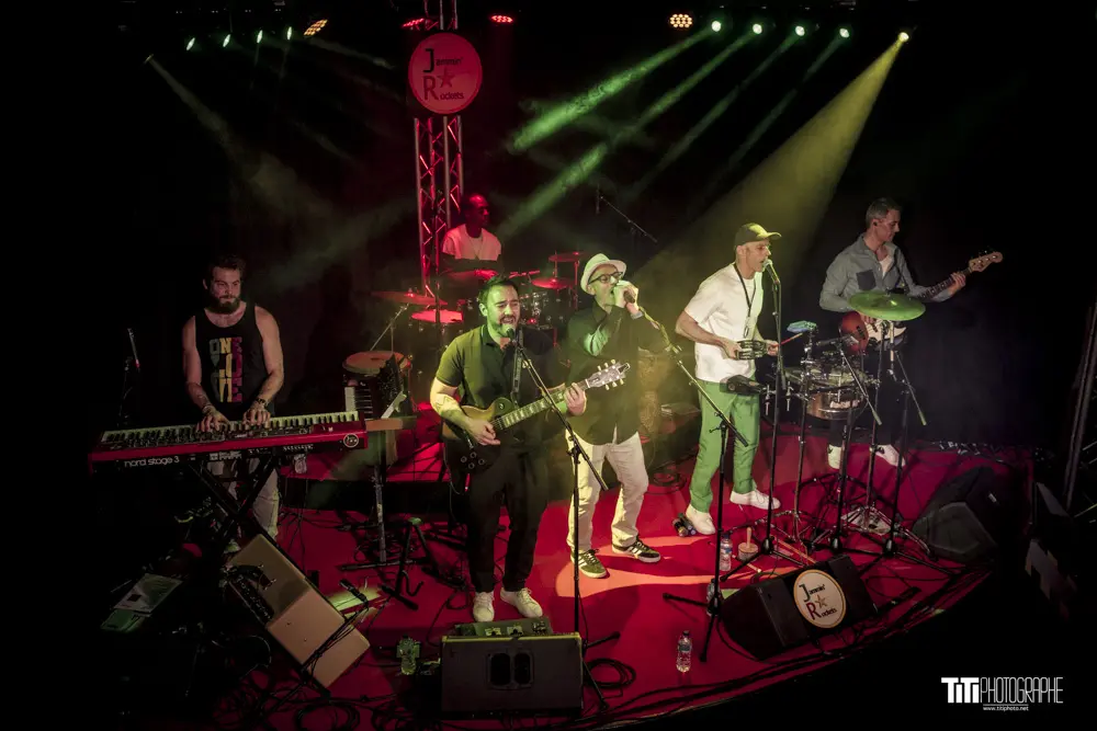 Les 6 musiciens de Jammin'Rockets chantant sur scène.