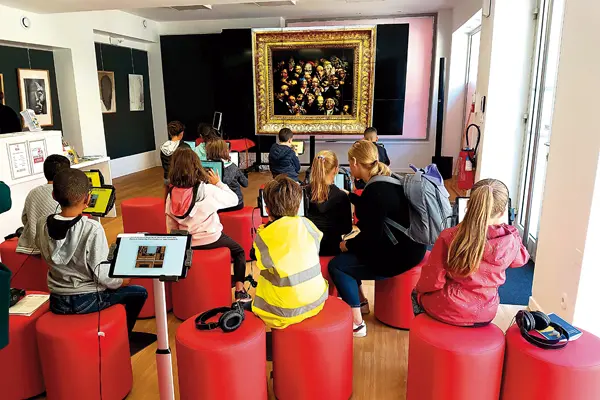 Photos représentant plusieurs enfants de dos face à une toile avec des tablettes numétiques devant eux