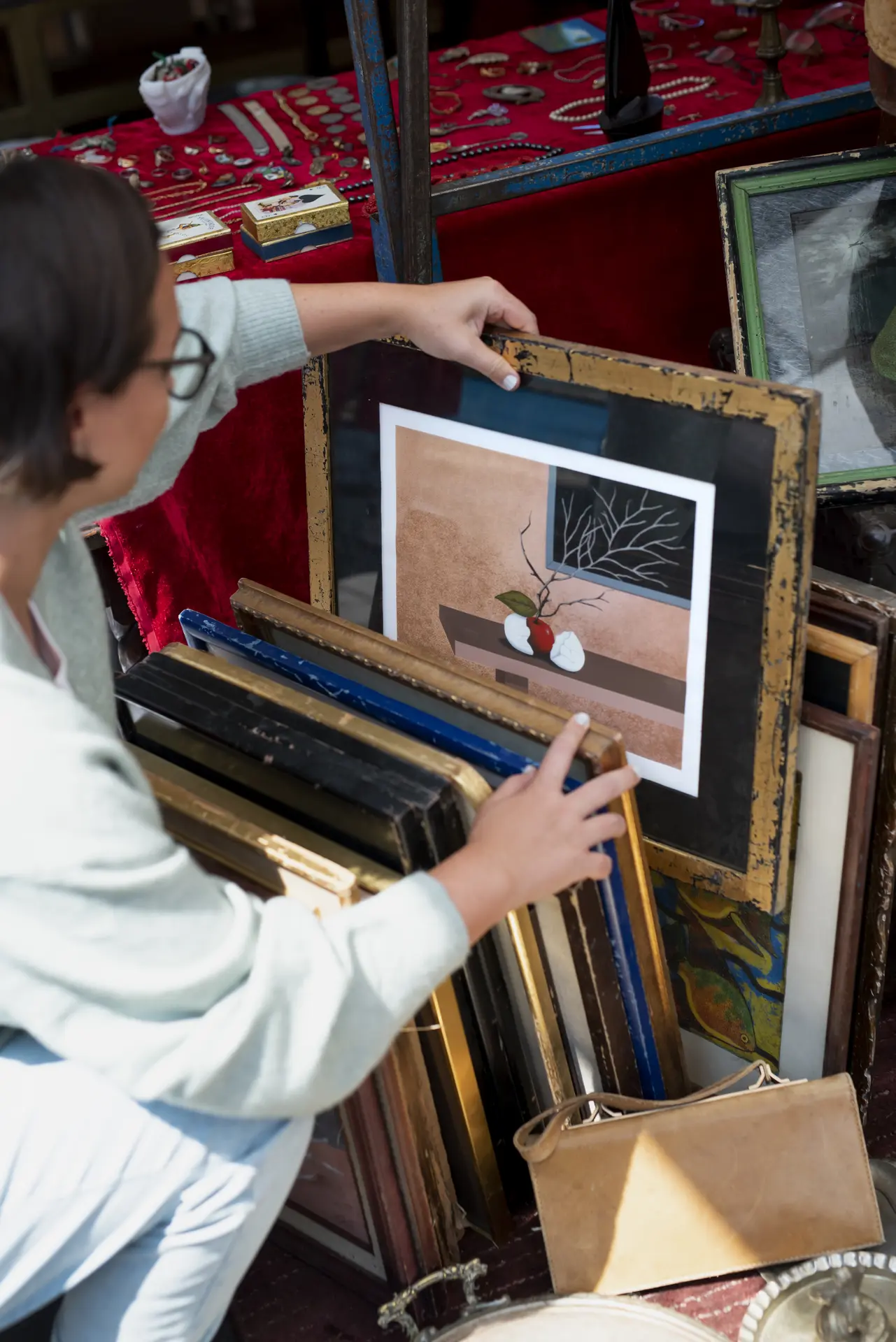 Une femme accroupie regarde une série de tableaux