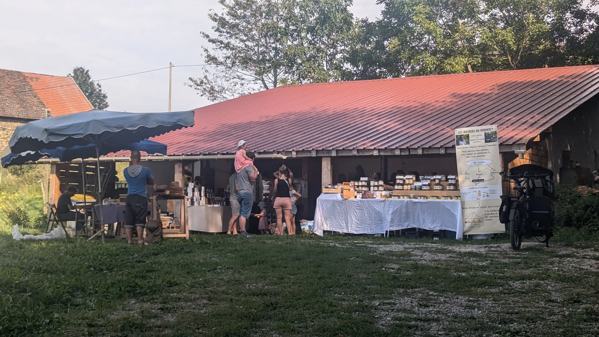 Marché fermier dans une petite grange avec différents producteurs (légumes, miel, tisanes, confitures, fromages etc...).