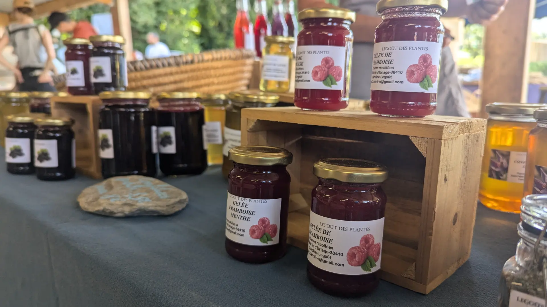 Étal avec des pots de confitures artisanales (framboises, cassis).