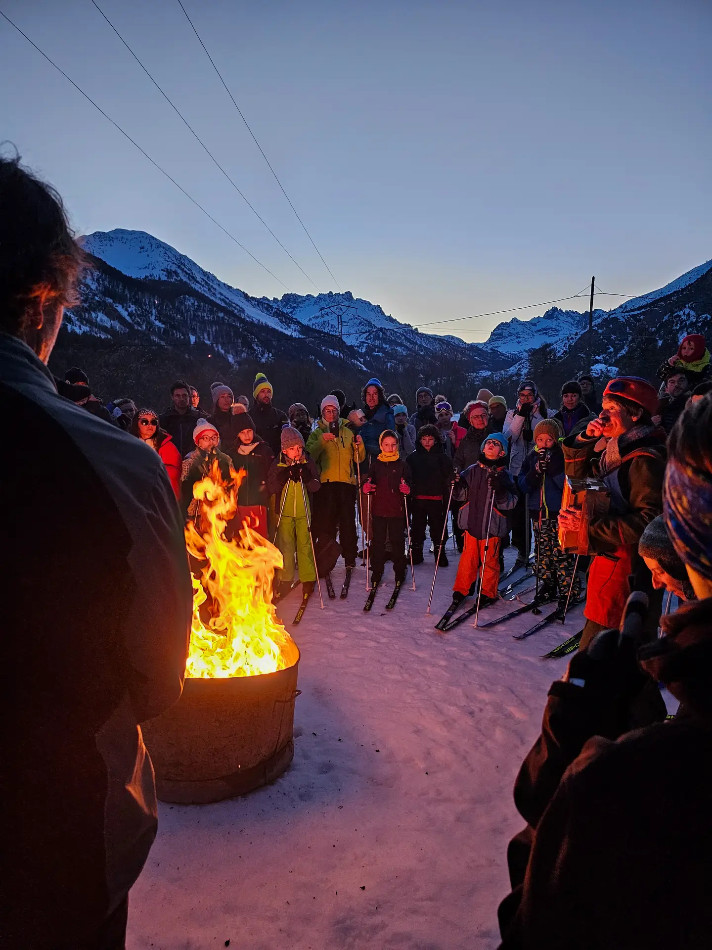 Skieurs avec flambeaux autour du feu