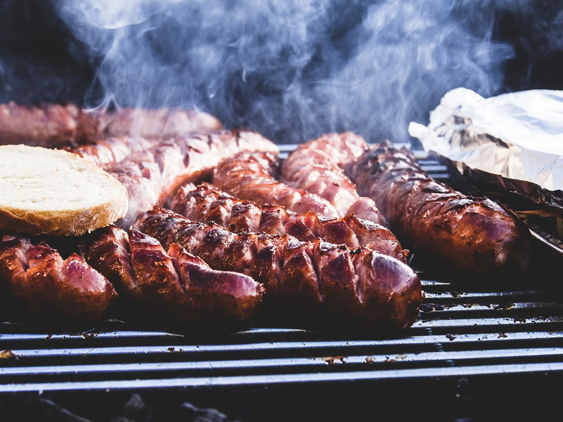 Photo représentant des saucisses et viande sur un grill