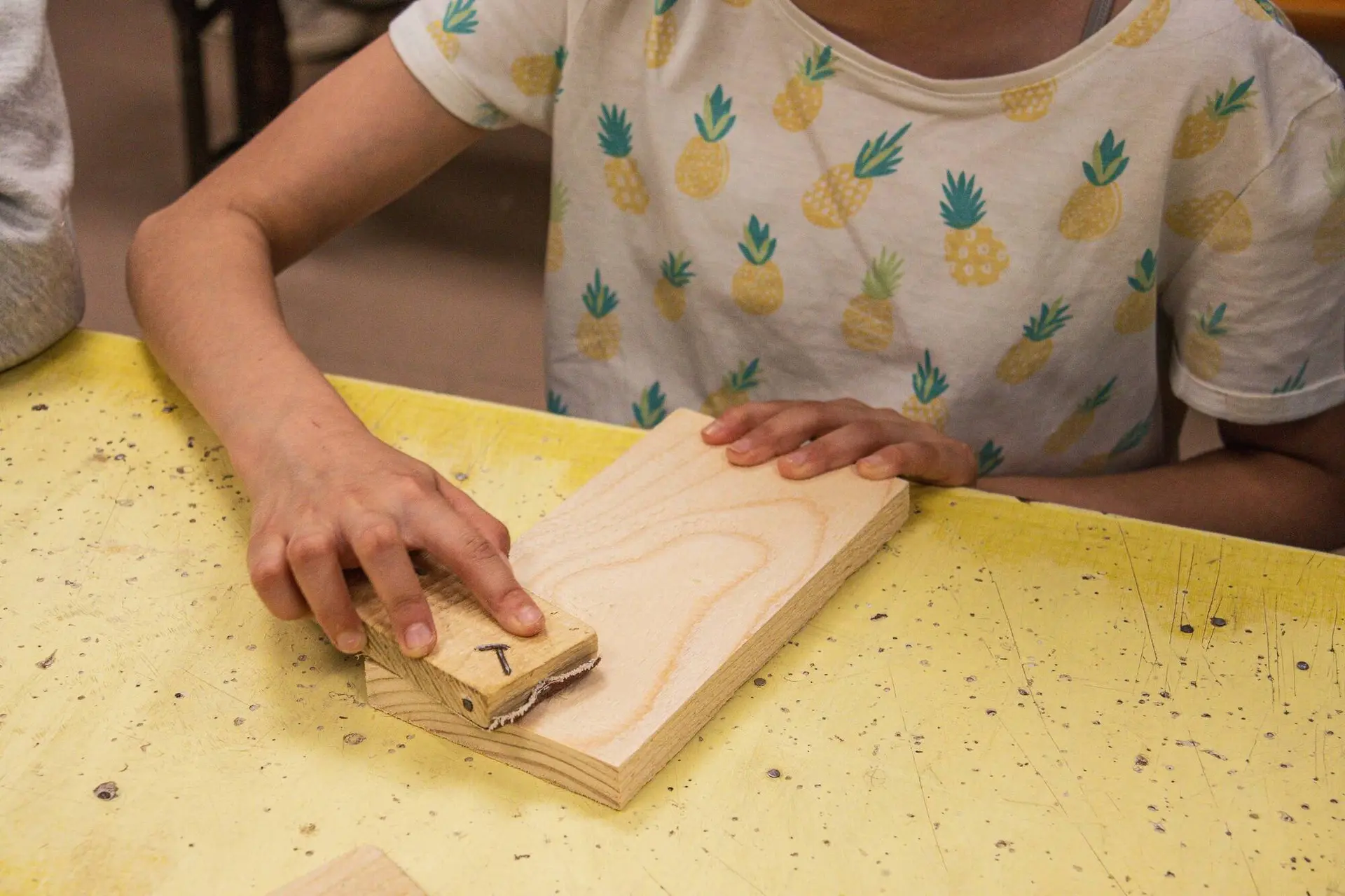 Enfant qui ponce sa planche en bois