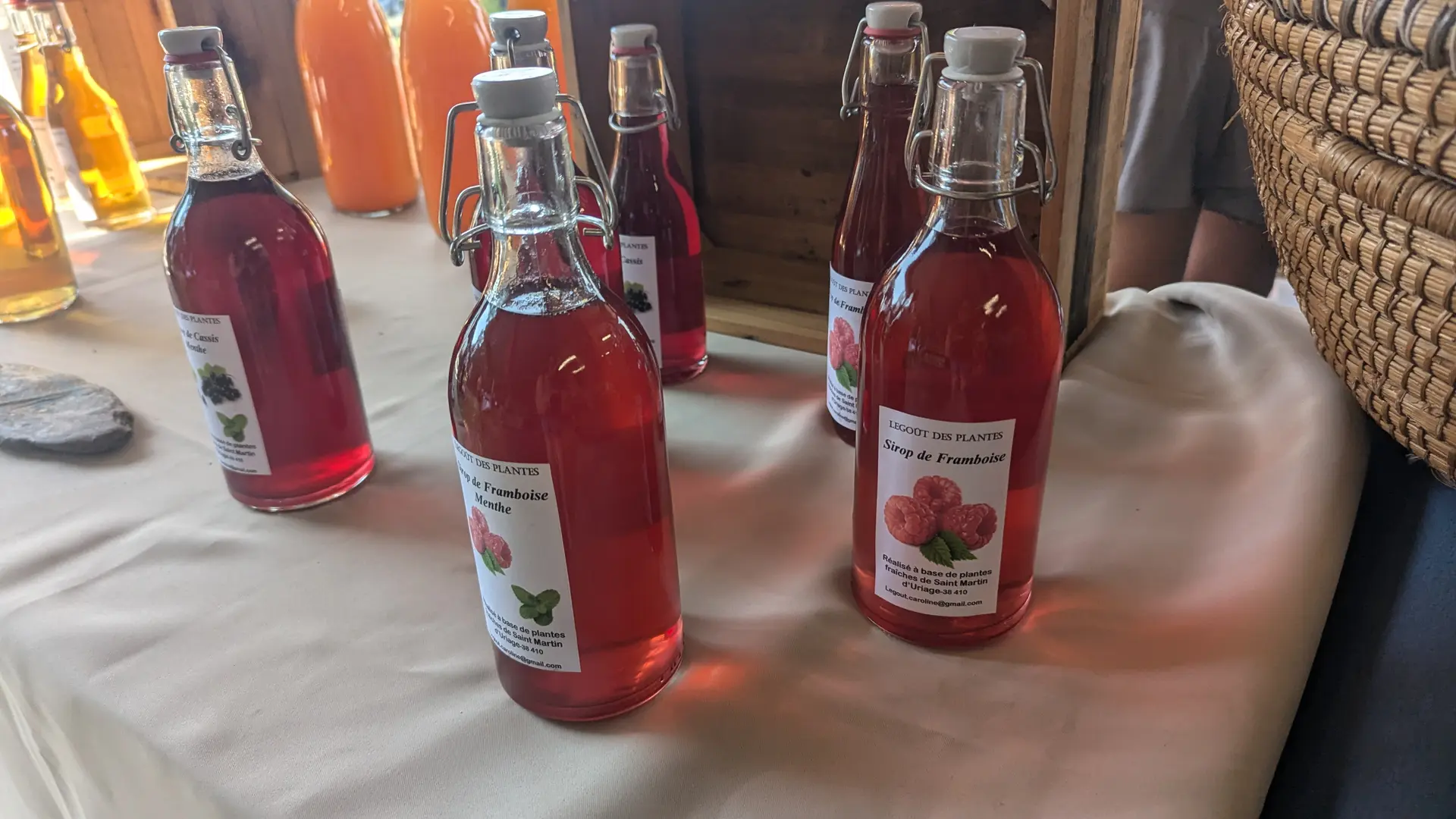 Étal avec des bouteilles en verre de vinaigre artisanal à la framboise.