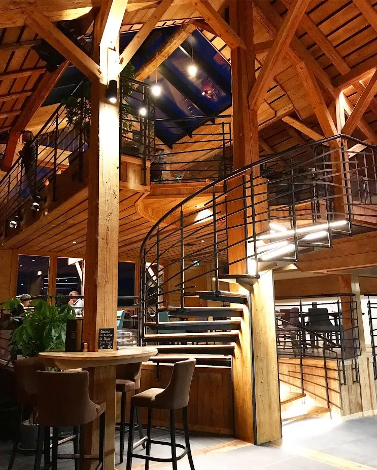 Salle principale du restaurant Le Toî du Monde, nichée dans la charpente de l'ancienne ferme