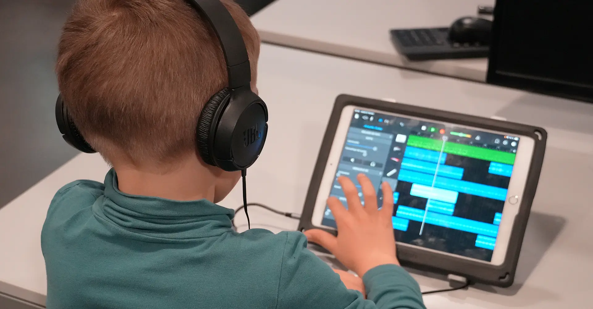 Un enfant écoute sa création musicale sur tablette