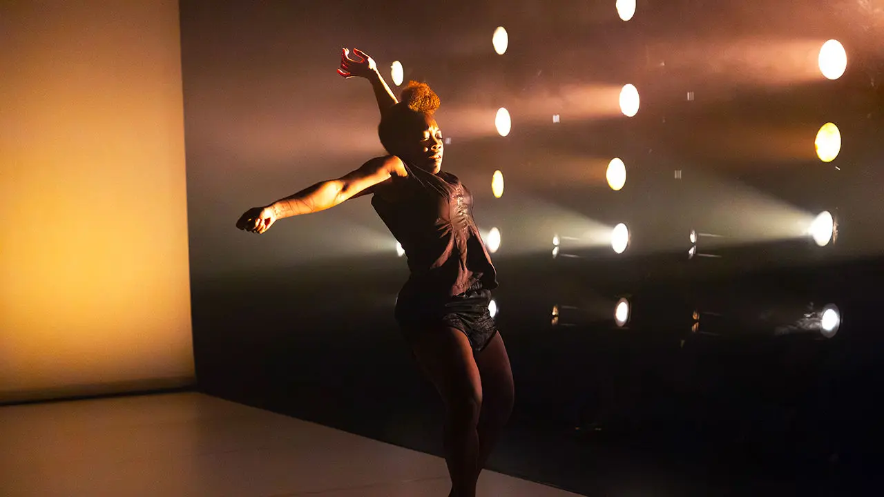 danseuse noire sur scène avec un fort éclairage contrasté