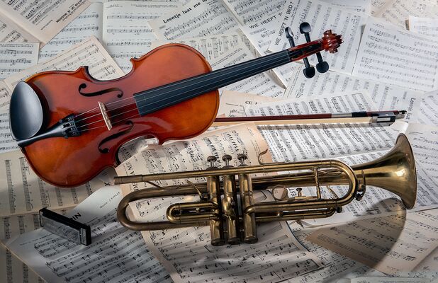 gros-plan-d-un-violon-et-d-une-trompette-sur-des-feuilles-de-notes-sous-les-lumieres