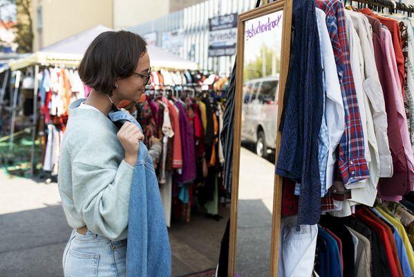 medium-shot-woman-holding-shirt