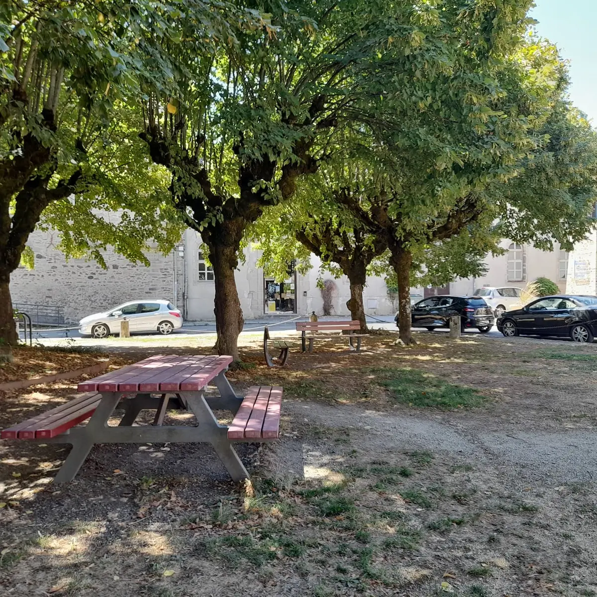 Bancs et tables de pique-nique sous les arbres dans le centre de Saint-Léonard de Noblart rue Roger Salengro