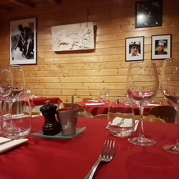 Intérieur du restaurant, décoration bois, tables et chaises ambiance chaleureuse, portraits et photos anciens sur les murs