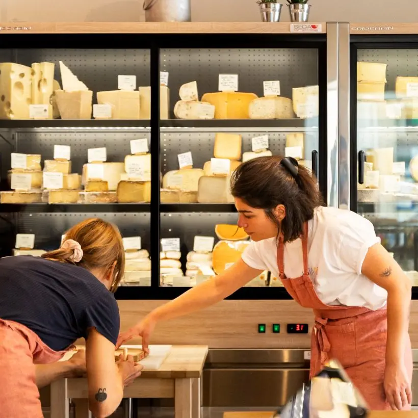 deux femmes en train de préparer un plateau de fromage