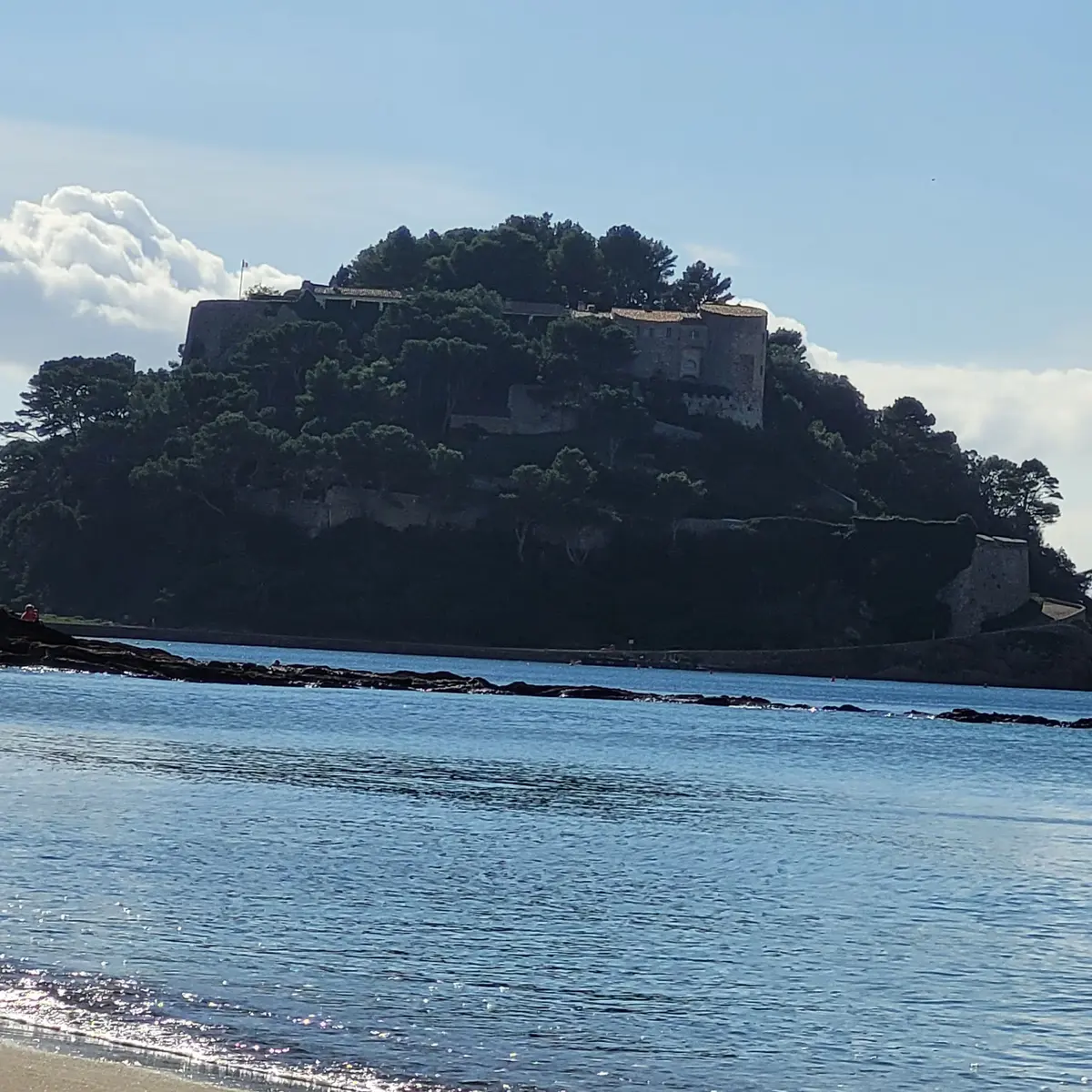 Vue sur le fort de Brégançon entouré d'une mer bleue et de végétation typiquement méditerranéenne