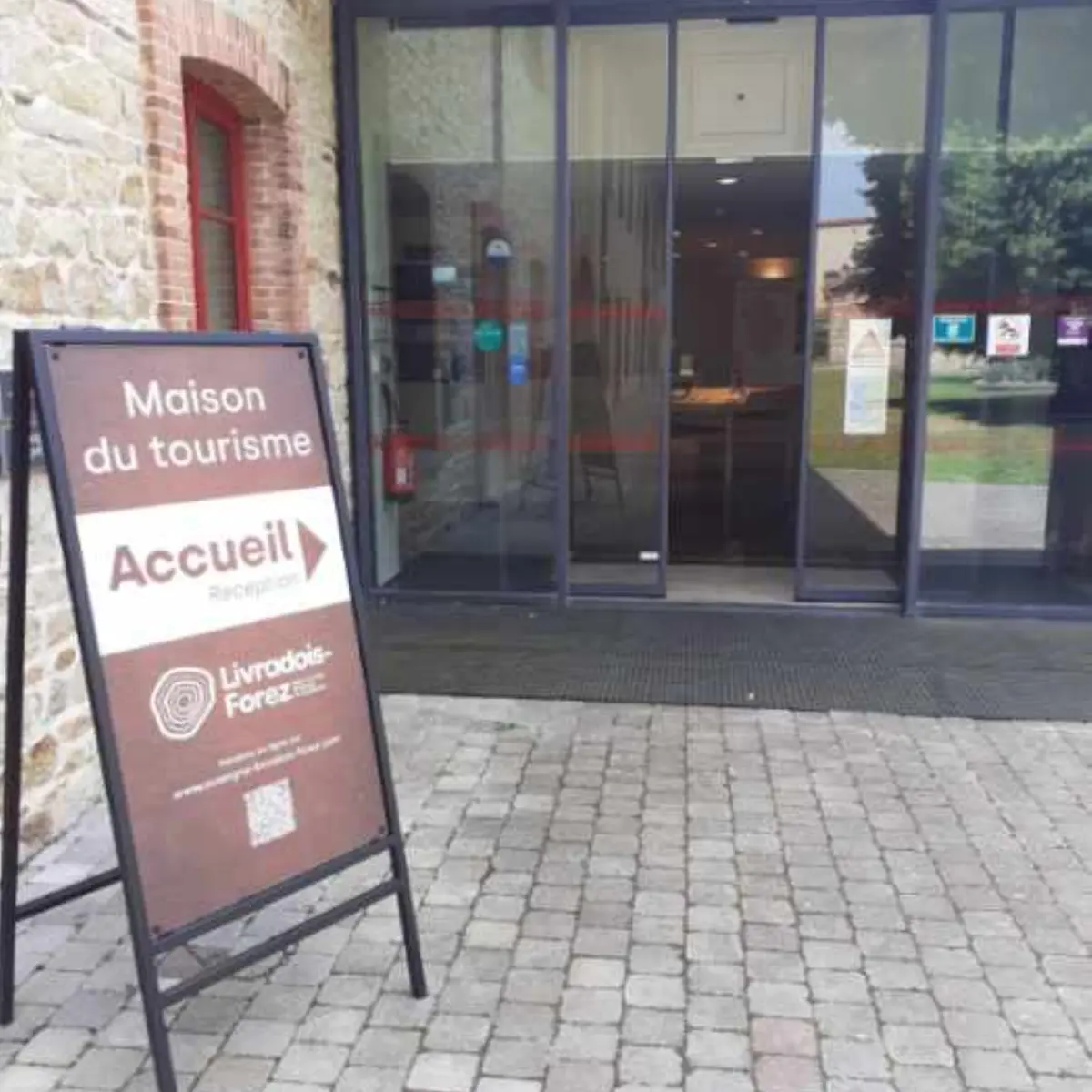 Pancarte d'accueil du Point d'information touristique de Lezoux et son entrée avec portes automatiques.