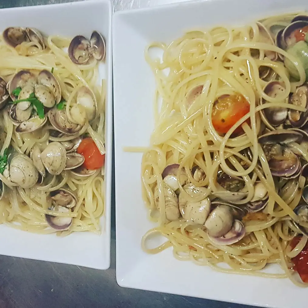 Plats de linguine avec crustacés, tomates cerise et basilic