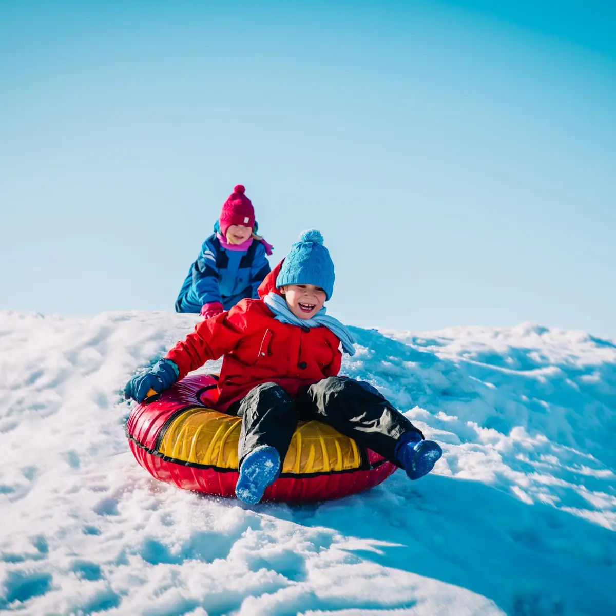Enfants qui jouent sur une bouée gonflable sur la neige
