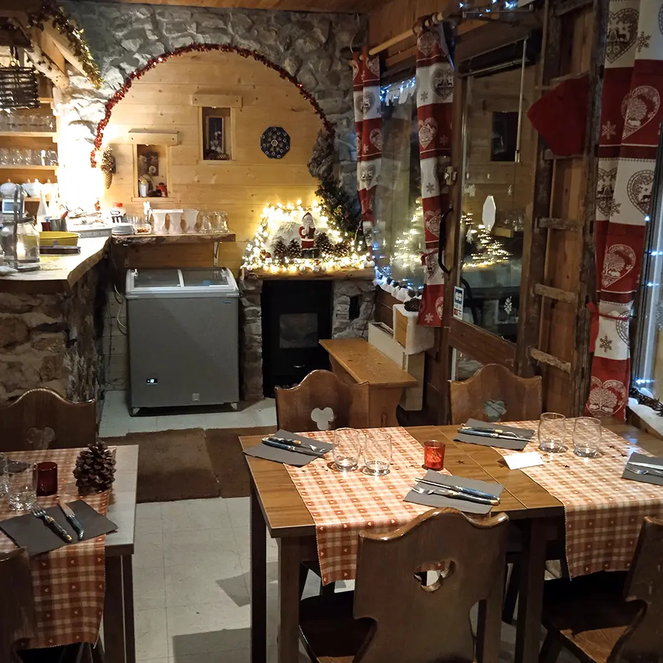 Intérieur de la crêperie, décoration de Noël, bois et pierre, tables à manger et chaises