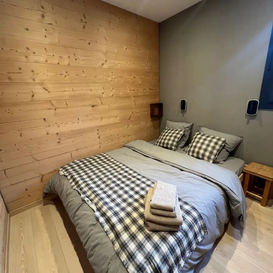 Bedroom with double bed, window and wooden interior