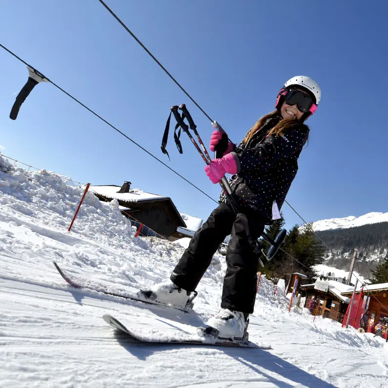 Un skieur remonte en téléski sur le domaine skiable débutants Le Grand-Bornand