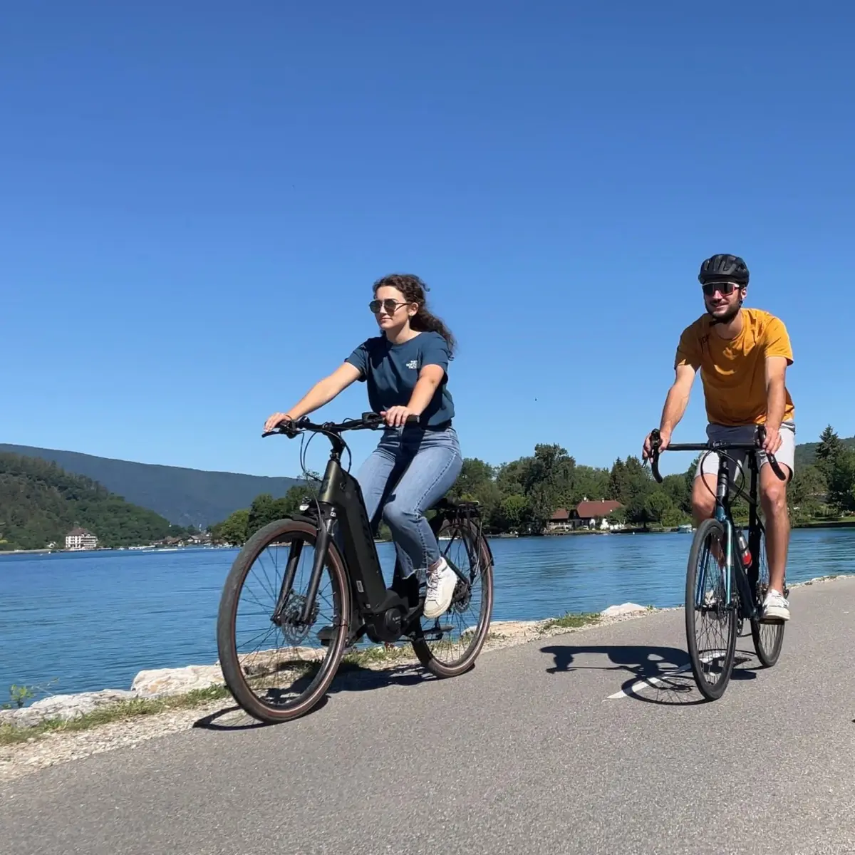 couple cycling by lake Annecy